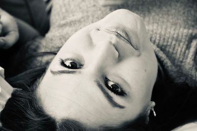 Close-up portrait of young woman lying down