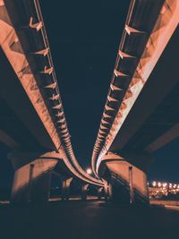Low angle view of illuminated bridge against sky at night