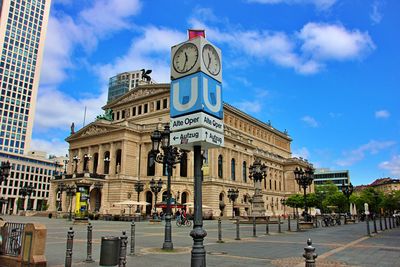 Buildings in city against cloudy sky