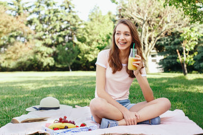 Portrait of a smiling young woman drinking drink