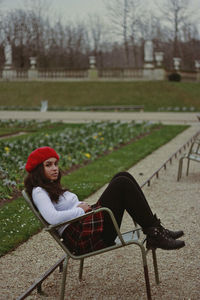 Young woman sitting on bench in park