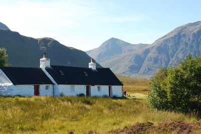 Houses on field against mountains