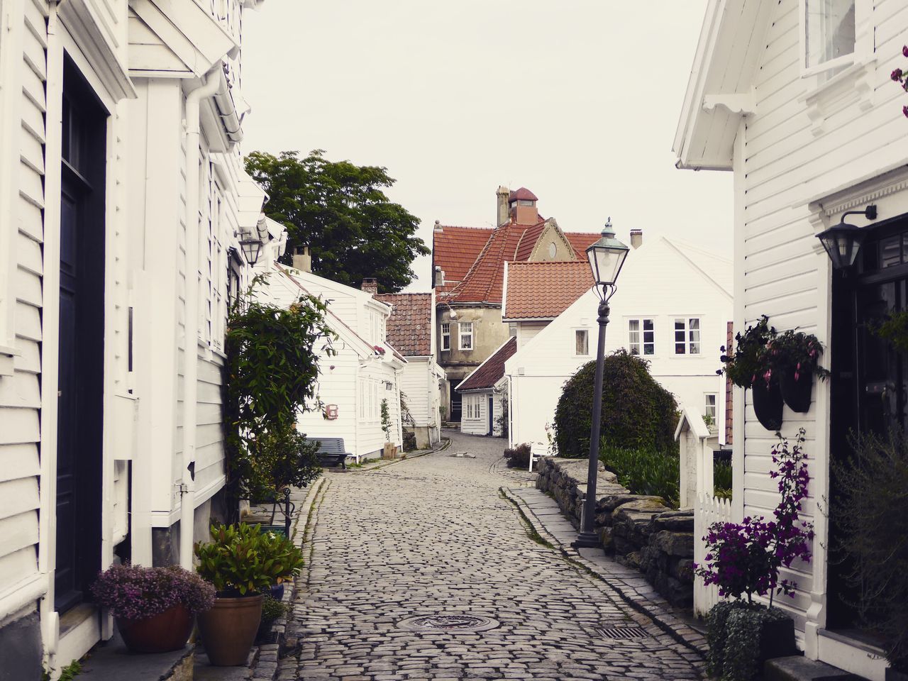 NARROW WALKWAY ALONG BUILDINGS IN BACKGROUND