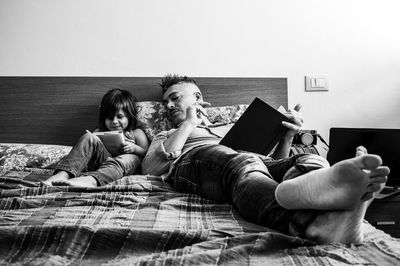 Rear view of women sitting on book at home