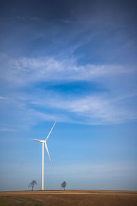 Windmill on field against sky