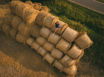 High angle view of woman sitting on hay stack