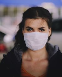 Portrait of beautiful woman wearing mask standing outdoors