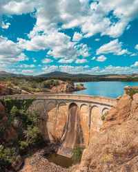 Arch bridge over river against sky