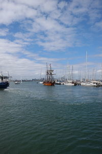 Sailboats in sea against sky