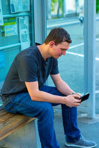 Full length of young man using mobile phone