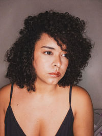 Close-up portrait of beautiful woman against wall