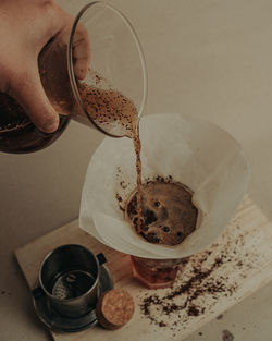 Midsection of person pouring coffee in cup