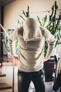 Rear view of man standing indoors