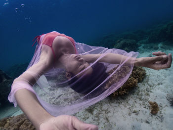 Low section of man swimming in sea