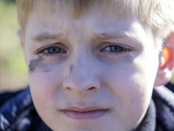 Close-up portrait of boy with soot smear on face