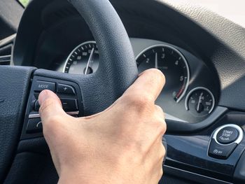 Midsection of man using mobile phone in car