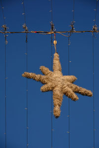 Low angle view of christmas decoration against blue sky
