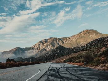 Road by mountain against sky