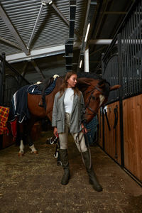 Full length of young woman in stable