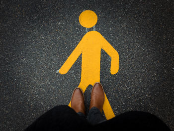 Low section of man standing on road