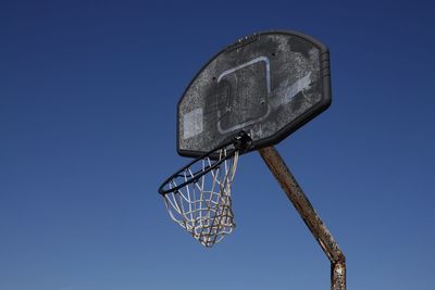 Low angle view of basketball hoop against clear blue sky