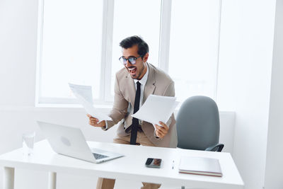 Side view of businessman using laptop at office