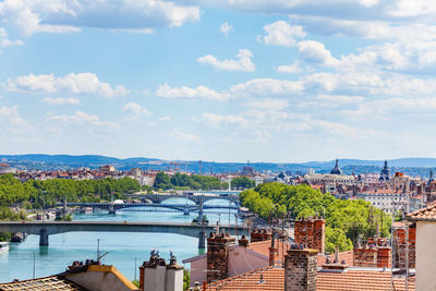 High angle view of city by buildings against sky