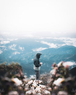 Rear view of man on mountain against sky