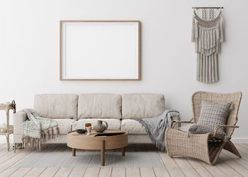 Empty horizontal picture frame on white wall in modern living room. mock up interior in boho style