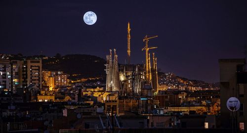 Illuminated cityscape against sky at night