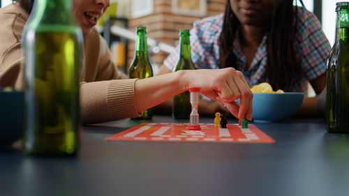 Midsection of friends playing board game