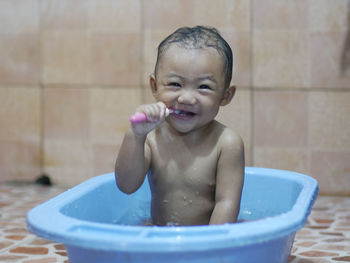 Portrait of shirtless baby boy in bathroom at home