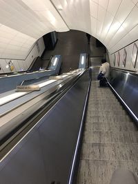 Rear view of woman on escalator