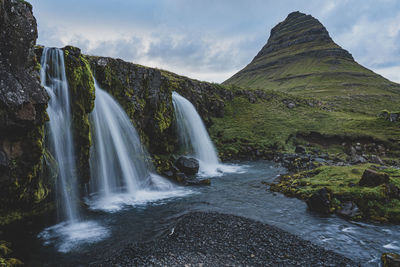 Scenic view of waterfall against sky