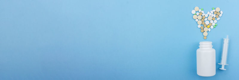 Close-up of white bottle against blue background