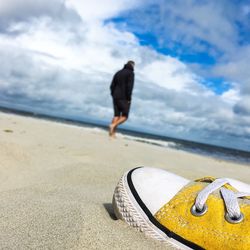 Close-up of man on beach against sky