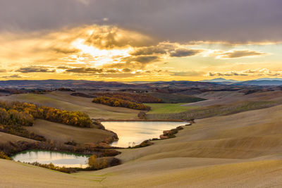 Scenic view of river against sky during sunset