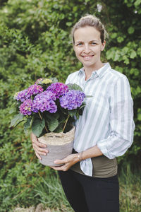 Portrait of a beautiful young woman holding flower in basket