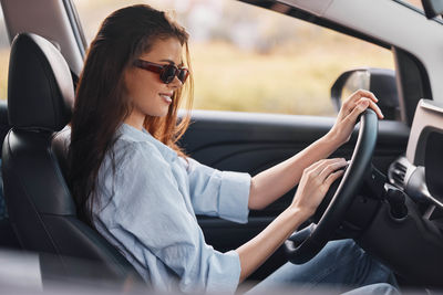 Young woman sitting in car