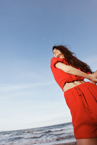 Rear view of woman standing at beach