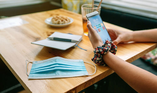 Woman holding smart phone on table