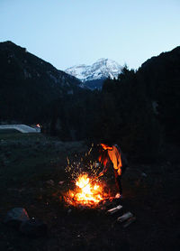Bonfire on field against mountain range