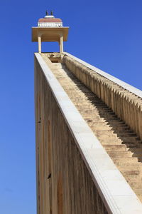 Low angle view of steps leading towards temple against clear blue sky