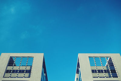 Low angle view of office building against blue sky