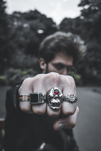 Close-up portrait of man holding camera against blurred background