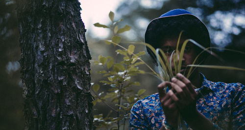 Man holding plants in forest