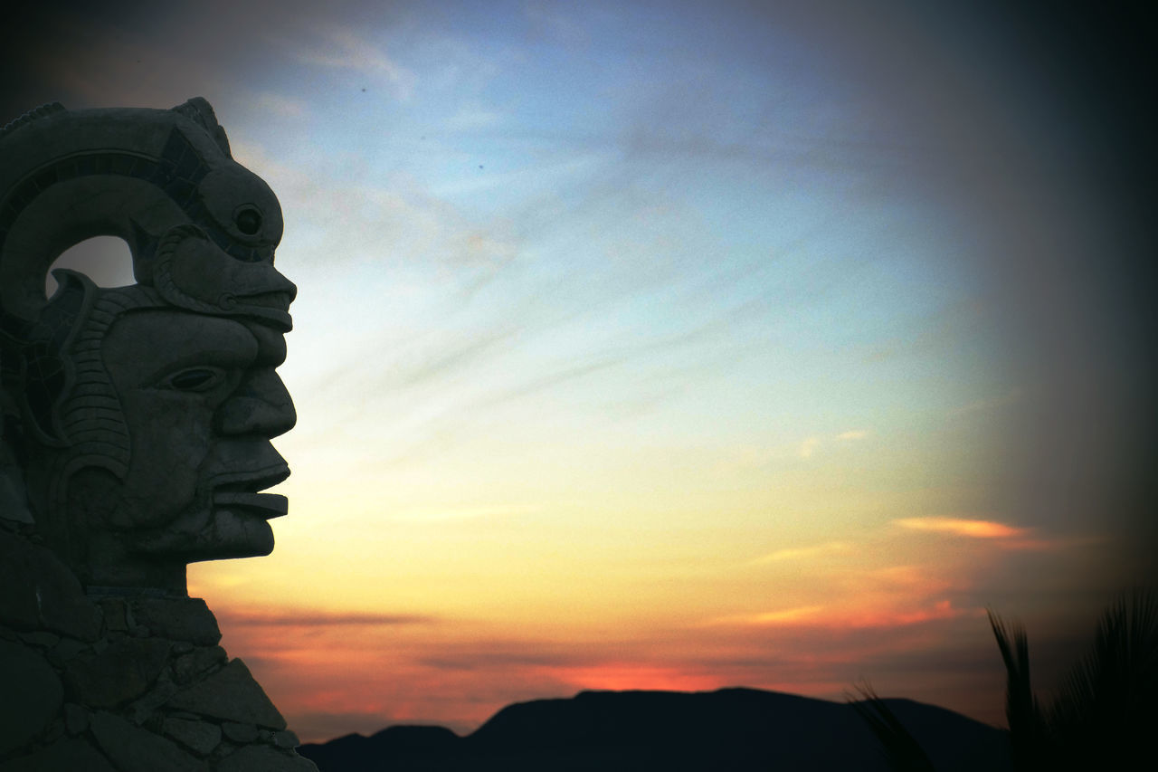 LOW ANGLE VIEW OF SILHOUETTE STATUE AGAINST SUNSET SKY