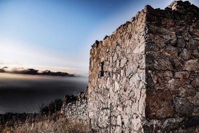 Rock formations by sea against sky