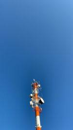 Low angle view of communications tower against clear blue sky