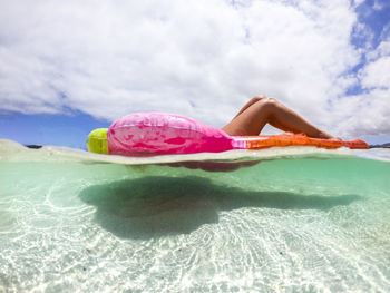 Man floating on sea against sky